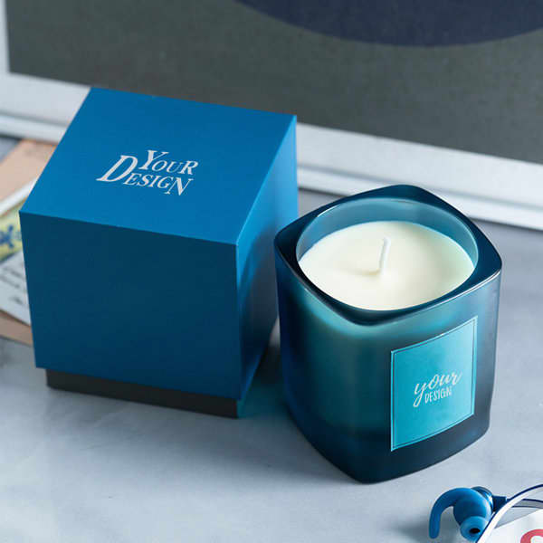 A blue scented candle in a square container with matching packaging, featuring a logo on both. Promo Scented Candle - Image 1