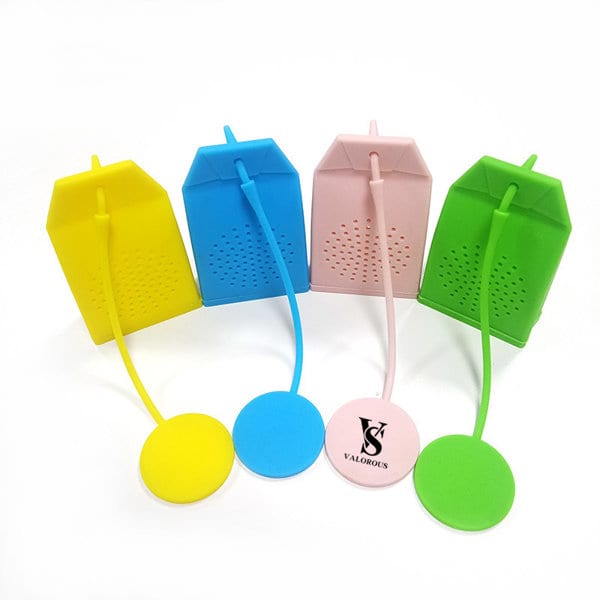 A collection of silicone tea infuser strainers in yellow, pink, green, and blue, featuring a tea bag shape and a round base. Silicone Bag Shaped Tea Infuser Strainer - Image 1