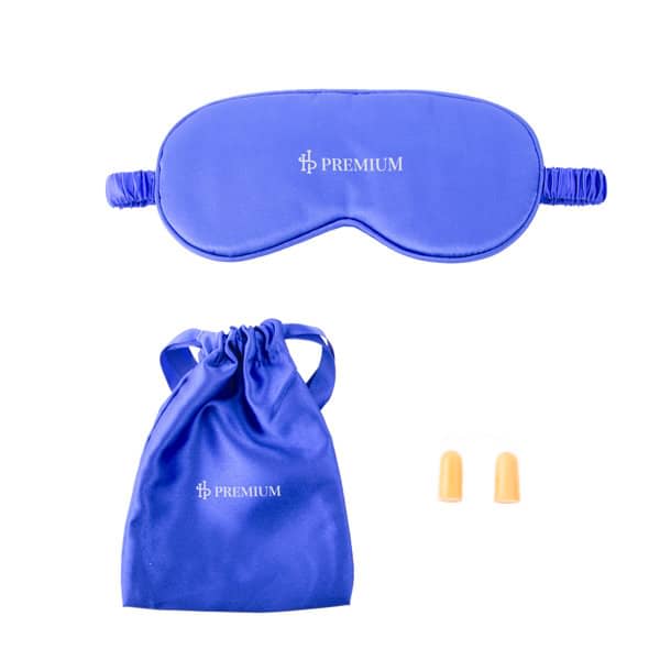 A blue silk sleep mask with a matching drawstring pouch and orange earplugs. The set includes a logo. Silk Sleep Mask And Earplugs Set - Image 1