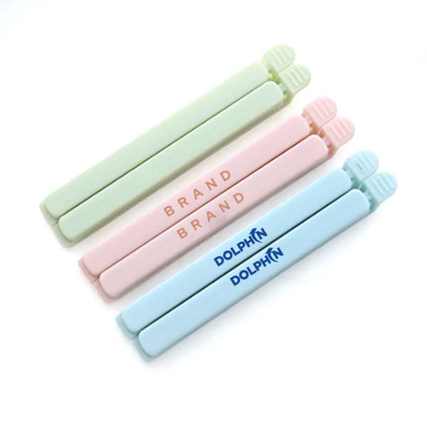 A set of three food bag sealing clips in pastel green, pink, and blue, each featuring a logo. 10cm Food Bag Sealing Clip - Image 1
