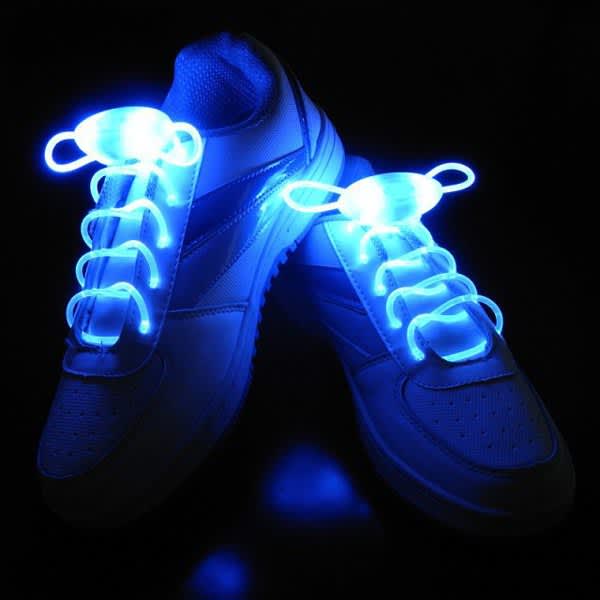 LED light shoelaces in bright blue, showcased on white sneakers against a dark background, with a logo visible. LED Light Shoelaces - Image 1
