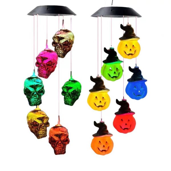 LED solar wind chime light featuring colourful skulls and pumpkin shapes with hat, hanging from a black top. LED Solar Halloween Wind Chime Light - Image 1