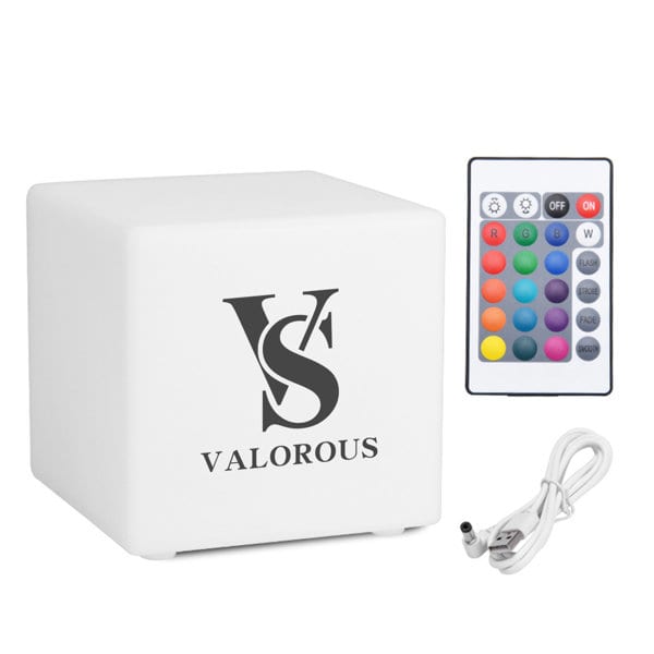 A large white colour cube with a logo, accompanied by a remote control and a charging cable. Large Color Cube With Remote Control - Image 1