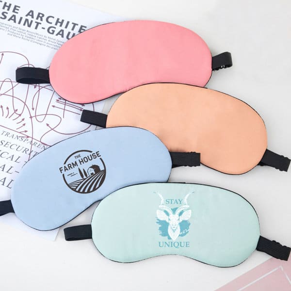 A set of sleep masks in pink, peach, blue, and green, featuring various designs and an adjustable strap. Sleep Mask With Adjustable Strap - Image 1