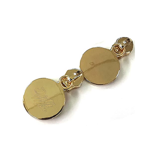 A gold Zinc Alloy Round Zipper Puller featuring two circular attachments and a logo. Ideal for clothing accessories. Zinc Alloy Round Zipper Puller - Image 1