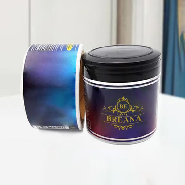 A round container with a black lid, featuring a gradient blue and purple design, and a logo on the front. Custom Printed Self Adhesive Sticker - Image 1