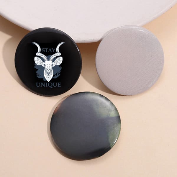 Three custom pinback buttons in black and grey, featuring a design with a goat illustration and a blank one. Custom Pinback Button - Image 1