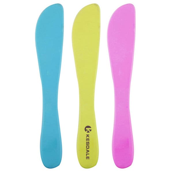 Three plastic multi-purpose butter knives in blue, yellow, and pink, featuring a logo on one knife. Plastic Multi Purpose Butter Knife - Image 1