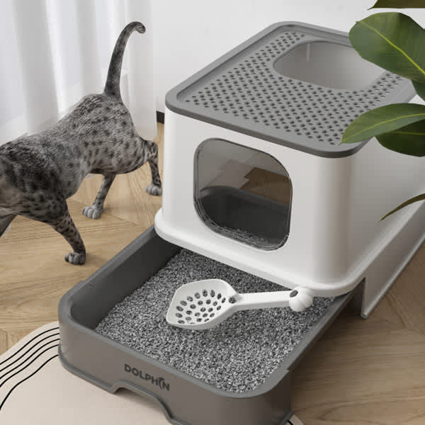A foldable plastic cat litter box in white and grey with a scoop, featuring a vented top and a removable tray. Foldable Plastic Cat Litter Box - Image 1