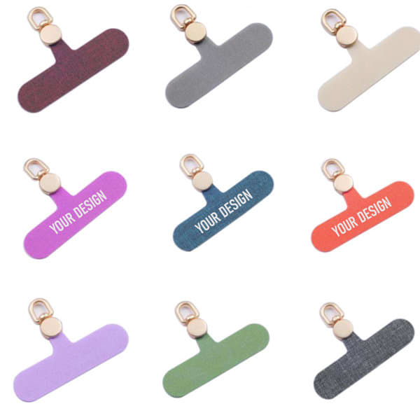 A collection of cell phone lanyard patches in various colours, each featuring a gold clip and customizable design spaces. Cell Phone Lanyard Patch - Image 1