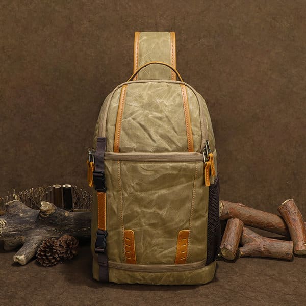 A waterproof sling camera backpack in olive green and brown, featuring multiple compartments and a logo. Waterproof Sling Camera Backpacks - Image 1