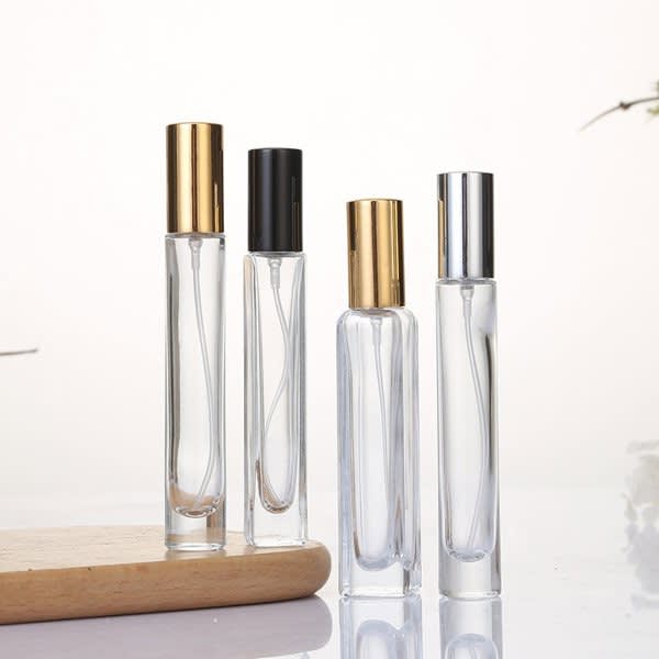 A set of four portable perfume atomizer bottles in clear glass with gold, black, and silver caps. Portable Perfume Atomizer Bottle - Image 1