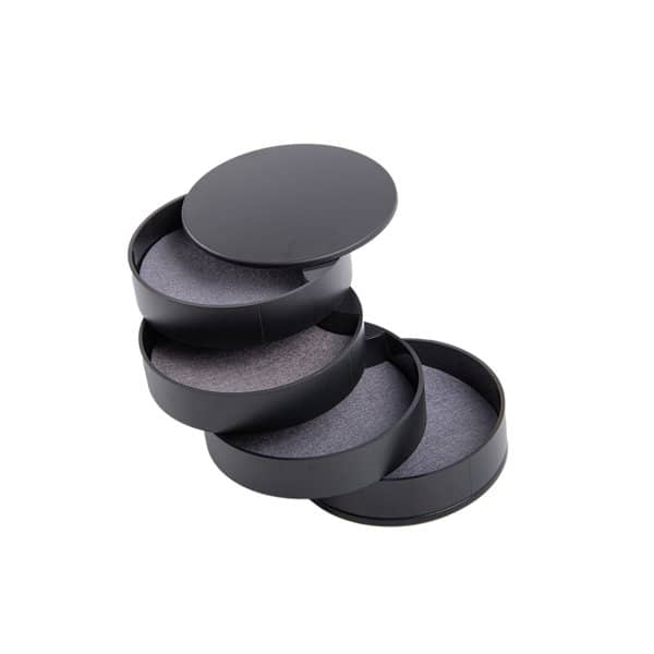 A rotating jewelry storage box in black with multiple tiers and soft interior lining. Includes a circular lid on top. Rotating Jewelry Storage Box - Image 1