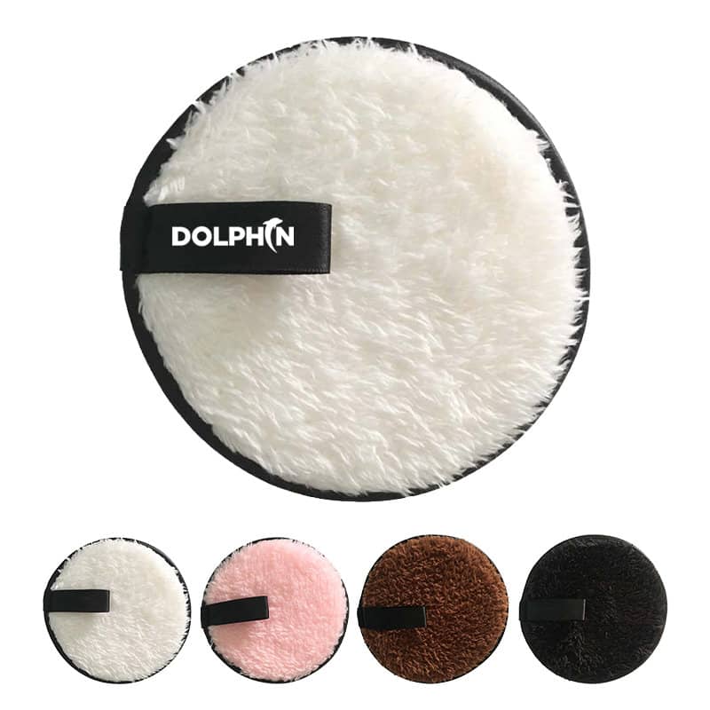 A round reusable makeup remover pad in white with a black band, surrounded by pink, brown, and black variants. Reusable Makeup Remover Pad - Image 1