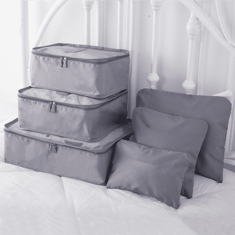 A set of six grey travel storage bags in various sizes, featuring zip closures and a simple design. 6 Pcs Travel Storage Bag Set - Image 1