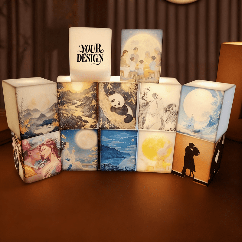 A set of illuminated silicone cube night lights featuring various artistic designs in soft white and pastel colours. Silicone Cube Tap Night Light - Image 1